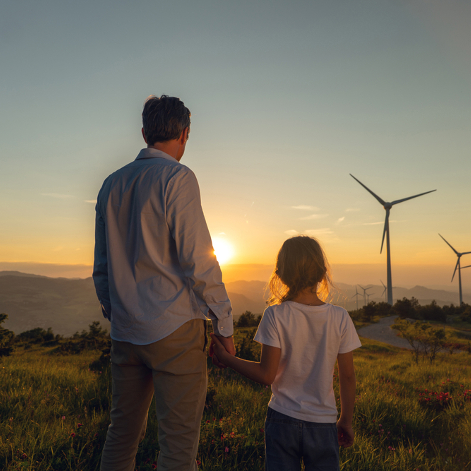 Father and daughter looking a wind turbines